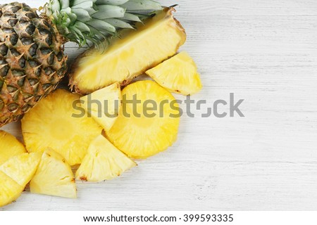 Cutting fresh pineapple on wooden background
