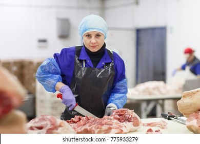 Cutting meat in slaughterhouse .