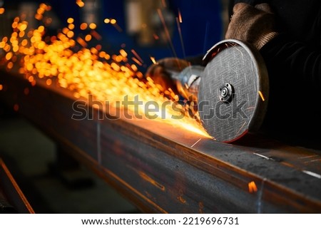 Cutting of metal beam with abrasive tool at metalwork plant