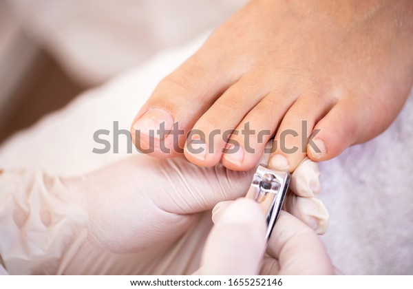 Cutting nails from fourth toe with nail clippers,\
pedicure concept