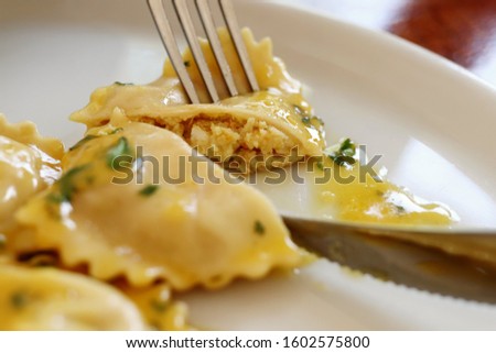Cutting Open / Displaying Insides of Ravioli with Pumpkin Filling and Butter Sauce