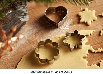 Cutting out flower and star shapes from rolled out dough to prepare traditional Linzer Christmas cookies