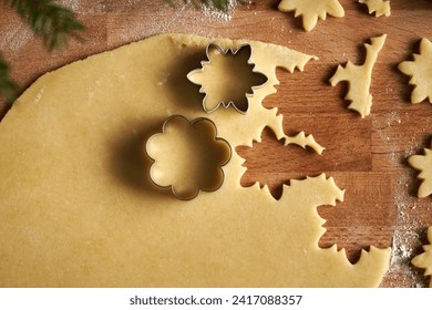 Cutting out shapes from rolled out pastry dough to prepare traditional Linzer Christmas cookies