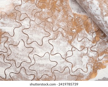 Cutting out star shaped cookies from rolled out shortbread dough on marble table dusted with flour, rolling pin, top view. Baking for st valentine's day - Powered by Shutterstock