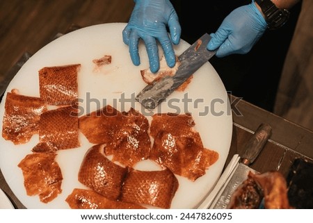 Cutting of Peking Roast Duck. Chef preparing meat.