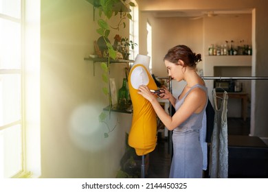 Cutting The Perfect Fit. A Young Designer Making A Garment In Her Workplace.