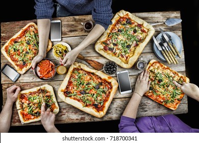 Cutting Pizza. Domestic Food And Homemade Pizza. Enjoying Dinner With Friends. Top View Of Group Of People Having Dinner Together While Sitting At The Rustic Table