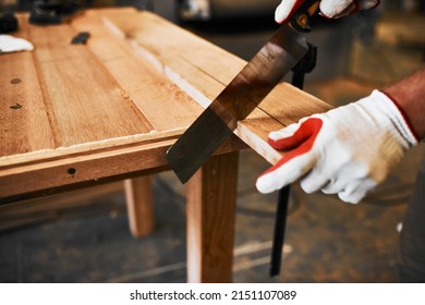 Cutting with precision is what he does best. Cropped shot of an unrecognizable carpenter cutting wood inside a workshop.