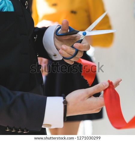 Cutting a red ribbon with scissors, inaugurated ribbon