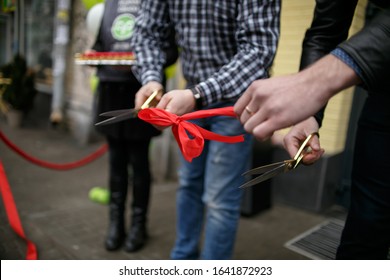 
Cutting A Solemn Red Ribbon At The Opening Of A Store.