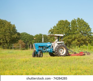 Cutting Weeds In The Pasture With A Tractor And A Bush Hog On A Beautiful Summer Day