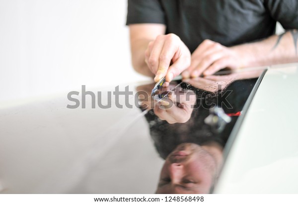 Cutting the window tinting film on the car.\
Professional car window tinting\
services.