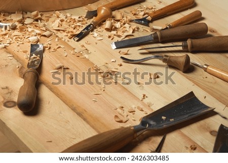 Cutting wood equipment in carver workshop, chisel, wooden plank.