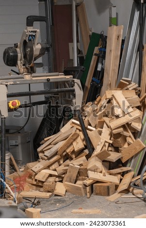Cutting wood, wood cutting machine next to a pile of cut wood, fuel for the fireplace