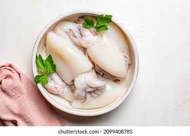 Cuttlefish sepia marine molluscs in a white plate, ready to be cooked. - Shutterstock ID 2099408785