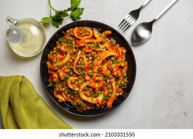 Cuttlefish Stew With Peas And  Tomatoes Or Seppie Con Piselli. On White Table Surface.