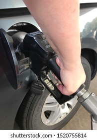 Cuyahoga Falls, OH/USA - October 1, 2019: White Lady's Arm And Hand Pumping Gas Into A Grey Van