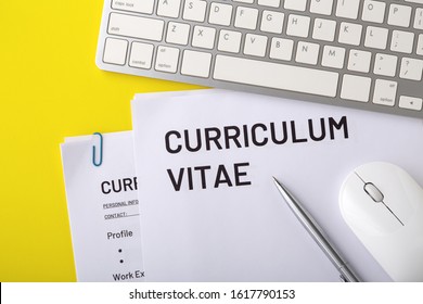 CV, curriculum vitae with computer keyboard, mouse, pen on yellow background, job interview