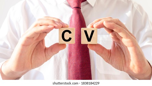 CV Word Written On Cube Blocks In Hands Of Recruiter Or Applicant In Shirt And Tie