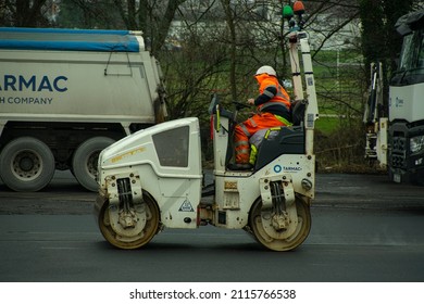 Cwmbran, Wales, UK - 01.28.2022: A Construction Worker Is Driving A Tarmac Roller.