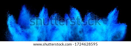 cyan blue holi paint color powder explosion isolated on dark black background. industry beautiful party festival concept