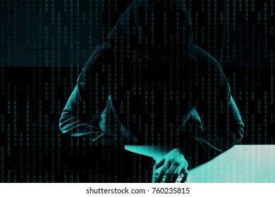 Cyber attack concept. Cyber crime concept. A hooded hacker working in front of his computer. Overlay with binary digits background.