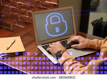 Cyber attack protection. Man using laptop with lock illustration on screen at table, closeup