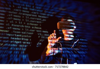 Cyber attack with unrecognizable hooded hacker using virtual reality, digital glitch effect.