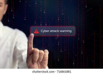 Cyber attack warning. Man securing computer data base by pressing alert sign for cyber attack on digital display. 