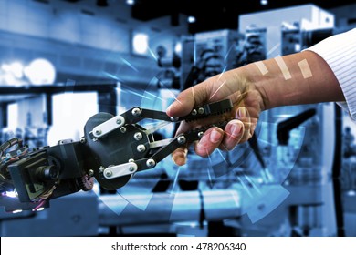 Cyber communication and robotic concepts. Industrial 4.0 Cyber Physical Systems concept. Robot and Engineerer human holding hand with handshake and graphic for background - Shutterstock ID 478206340