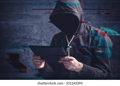 Cyber Crime Concept With Digital Glitch Effect Depicting Faceless Hooded Person With Digital Tablet Computer Hacking Online Accounts