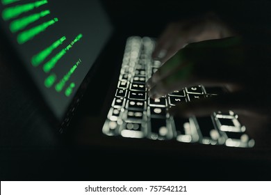 Cyber Crime Concept: Hands Of A Person Hacking On Laptop In The Darkness