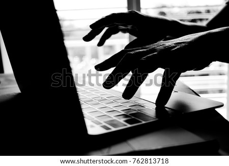 Cyber crime hand reaching out through laptop computer and attack signifying in internet theft while using online banking, Payment Security Concept. Anonymous Hacked in Black
