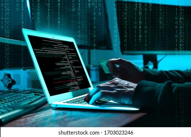 Cyber criminal with credit card hacking system at table, digital binary code on background