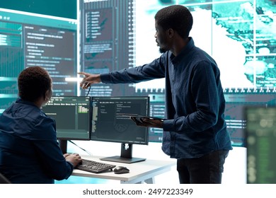 Cyber defense team working in a governmental security operations center. Experts ensuring cybercrime prevention and data breach protection, examining information on a big screen. - Powered by Shutterstock