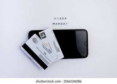 Cyber monday lettering with smartphone and credit card on white background. Online shopping concept.