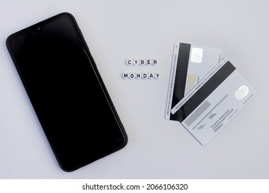 Cyber monday lettering with smartphone and payment card on white background. Online shopping concept.