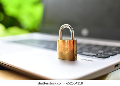 Cyber safety concept, locked and key on laptop computer keyboard ,key to unlock before green background.Key and Lock on Thai's keybroad ./golden lock on notebook ,thai keybroad
