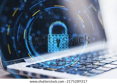 Cyber security and data protection concept with digital graphic glowing blue lock symbol with keyhole on modern laptop background, double exposure