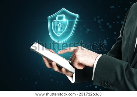 Cyber security and internet protection access concept with glowing keyhole inside closed padlock and shield hologram above businessman using digital tablet on abstract dark pixel background