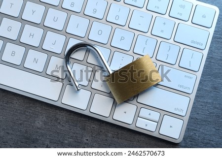 Cyber security. Open padlock and keyboard on dark grey table, top view