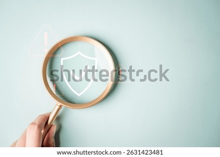 Cyber security system technology. Secure information privacy. Crime network technology. A person is holding a magnifying glass over a green background with a shield on it.