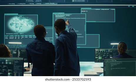 Cyber security team conducting cyber surveillance in a governmental control room. Experts group hacking activities, malware protection and data breach prevention in high tech agency. Camera B. - Powered by Shutterstock