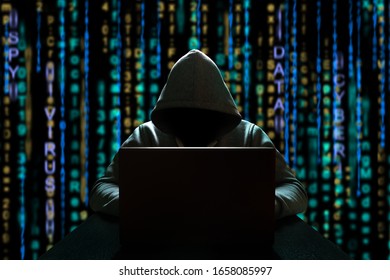 Cyber threat of an unknown hacker sitting in front of a computer against a background of binary code. Cyber security