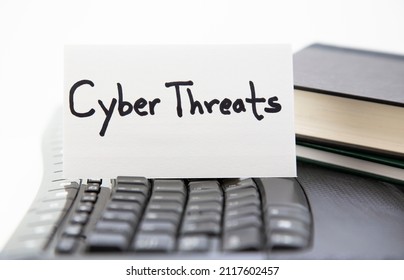 Cyber Threats And Digital Warfare Expressed On Lettered Card On Computer Keyboard On White Background