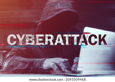 Cyberattack concept, hooded computer hacker working on laptop, glitch effect added in post, selective focus