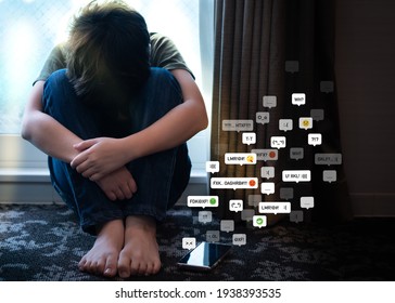 Cyberbullying - Social Media Harassment Concept. Young Asian Preteen, Teenager Boy Sitting Alone In The Room Feeling Frustrated After Reading Bad Comments. Text Emoticons, Teen Mental Health, Online.