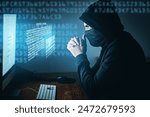 Cybercrime, hacker and thinking at computer for virus, overlay and futuristic at desk. Male criminal, hoodie and ready for coding, cyber attack and programming for malware with tech, scam and data