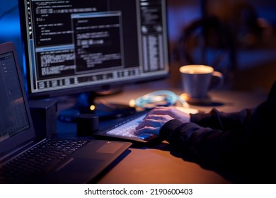 cybercrime, hacking and technology concept - close up of hacker in dark room writing code or using computer virus program for cyber attack - Shutterstock ID 2190600403