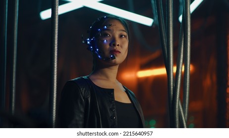 Cyberpunk girl in a black leather jacket and intense facial expressions. Asian girl with one-eyed glasses and headset. Trapped behind black hanging rods. Cyborg, sci-fi, Neon lights.